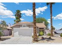 Charming single-story home features a well-manicured front yard, a two-car garage, and a classic stucco facade at 6997 Ray Charles Ln, Las Vegas, NV 89119
