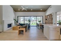 Open living room with fireplace, modern decor, and views of the lush green golf course at 9425 Villa Ridge Dr, Las Vegas, NV 89134