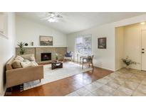 Cozy living room features a brick fireplace, ceiling fan, and a bright window at 1012 Winwood St, Las Vegas, NV 89108