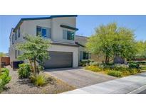 Charming two-story home featuring a brick driveway, a two-car garage and professionally landscaped front yard at 1321 Hudson Creek Pl, North Las Vegas, NV 89084