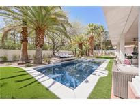Inviting backyard pool with lush landscaping and lounge chairs for ultimate relaxation and outdoor enjoyment at 2231 S Tioga Way, Las Vegas, NV 89117