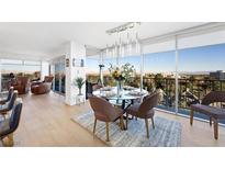 Bright dining area featuring floor-to-ceiling windows with city views, a modern chandelier, and seating for six at 3111 Bel Air Dr # 7F, Las Vegas, NV 89109