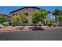 Tan two-story condo building featuring well-maintained landscaping and a red tile roof in a desert setting at 3320 Cactus Shadow St # 201, Las Vegas, NV 89129