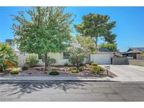 Charming single-story home with mature trees, a well-maintained lawn and a two car garage at 4445 Peterson Dr, Las Vegas, NV 89103