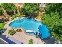 An aerial shot showcases a luxurious pool and spa surrounded by lush landscaping and a serene backyard oasis at 5186 San Milano Ave, Las Vegas, NV 89141
