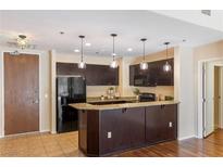 Modern kitchen featuring dark cabinets, granite countertops, and stylish pendant lighting at 8255 Las Vegas Blvd # 117, Las Vegas, NV 89123