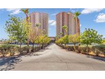 Beautiful landscaped grounds lead to a grand two-tower condominium building on a sunny day with blue skies at 8255 Las Vegas Blvd Blvd # 719, Las Vegas, NV 89123