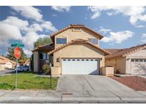 Charming two-story home with a two-car garage, desert landscaping, and a well-maintained front lawn at 1942 Old Mill Ln, Henderson, NV 89014