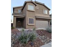 Inviting two-story home featuring a two-car garage and low-maintenance desert landscaping at 2077 Alki Beach Ave, Laughlin, NV 89029