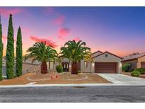 Charming single-story home with desert landscaping, palm trees, and a two-car garage under a colorful dusk sky at 2114 Twin Falls Dr, Henderson, NV 89044