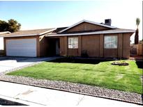 Charming single-story home with a well-manicured lawn and a two-car garage at 266 Lyra Ln, Las Vegas, NV 89110