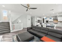 Bright, open living area with modern furnishings, ceiling fan, and staircase access at 424 Vigo Port St, Las Vegas, NV 89138