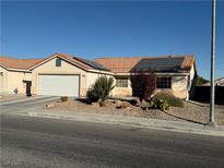 Charming single-story home with a two-car garage, desert landscaping, and roof-mounted solar panels at 4636 Ferrell St, North Las Vegas, NV 89031