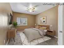 This staged bedroom offers a ceiling fan and a comfy-looking bed at 5655 E Sahara Ave # 1052, Las Vegas, NV 89142