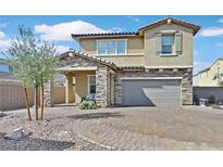Charming two-story home featuring stone accents, a well-manicured yard, and a welcoming covered front porch at 625 Honesty Ct, Henderson, NV 89011
