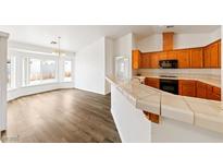 Bright living room featuring wood floors, a dining area, and an open layout with an adjacent kitchen at 654 Mazelle Ln, Pahrump, NV 89060