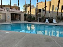 Inviting community pool with lounge chairs, perfect for relaxation and enjoying the outdoors at 6865 Tamarus St # 202, Las Vegas, NV 89119