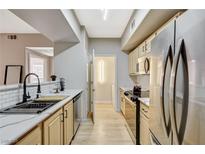 Updated kitchen features stainless steel appliances, a modern faucet, and light wood cabinets at 8000 Badura Ave # 1007, Las Vegas, NV 89113