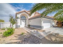 Charming single-story home featuring desert landscaping, a two-car garage, and an arched entryway at 1512 Bellglen Dr, Las Vegas, NV 89128