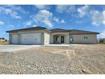 Inviting single-story home with a spacious three-car garage and low-maintenance desert landscaping at 1580 S Tiptop Trl, Pahrump, NV 89048