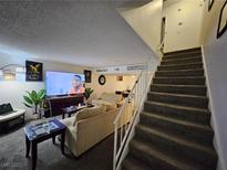 Open living area featuring plush seating, modern decor, and adjacent staircase at 2200 Comet Ave # D, North Las Vegas, NV 89030
