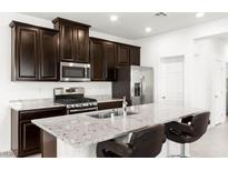 Modern kitchen features stainless steel appliances, granite countertops and dark wood cabinetry at 2495 Sunflower Days Ave # 2052, North Las Vegas, NV 89031