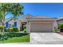 Charming single-story home featuring desert landscaping, blue shutters, and a two-car garage at 2687 Ivoryhill St, Las Vegas, NV 89135