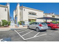 Charming condo complex with covered parking and blue accents under a bright blue sky at 2725 S Nellis Blvd # 2084, Las Vegas, NV 89121