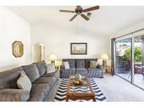 Bright living room featuring vaulted ceilings, ceiling fan, neutral color scheme and sliding glass door to the outdoors at 3013 Sungold Dr, Las Vegas, NV 89134