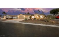 Charming single-story home with a well-maintained desert landscape and a two-car garage at sunset at 4016 Tyler William Ln, Las Vegas, NV 89130
