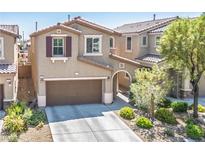 Inviting home featuring a two-car garage, landscaped front yard, and a charming facade at 4786 Castel Martini Ct, Las Vegas, NV 89147