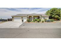 Charming single-story home featuring a well-manicured lawn, three-car garage, and stone accents at 5500 Santovito St, Pahrump, NV 89061