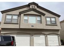 Two-story home with three-car garage and stucco exterior under cloudy sky at 6462 Saddle Up Ave # 103, Henderson, NV 89011