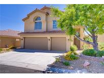 Beautiful two-story home featuring a two-car garage, well-maintained landscaping, and a classic stucco exterior at 7813 Paper Flower Ct, Las Vegas, NV 89128