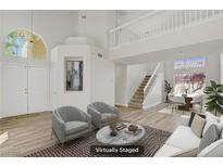Bright, staged living room features soaring ceilings, natural light, modern decor, and open floor plan at 7813 Paper Flower Ct, Las Vegas, NV 89128