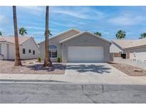 Charming single-story home with a two-car garage and xeriscaped front yard at 887 Cozy Valley St, Henderson, NV 89015