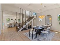 Bright dining area featuring a unique staircase design and modern light fixture at 11550 Lampeter Ct, Las Vegas, NV 89138