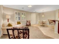 Bright living room with neutral walls, plush sofa, and unique accent chairs at 1560 Plaza Centre Dr # 103, Las Vegas, NV 89135