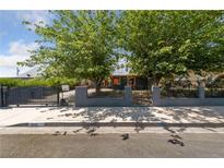 Charming home with an eye-catching wrought-iron gate and mature trees, offering both curb appeal and privacy at 1916 Canosa Ave, Las Vegas, NV 89104