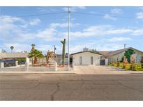 Charming single-story home featuring desert landscaping, a white fence, and a long driveway at 4301 Fortune Ave, Las Vegas, NV 89107