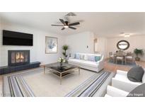 Bright living room features a cozy fireplace, ceiling fan, and a comfortable seating area with lots of light at 4301 Fortune Ave, Las Vegas, NV 89107