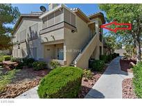 View of the exterior of the home featuring tan stucco, a walkway, and mature landscaping at 5710 E Tropicana Ave # 2178, Las Vegas, NV 89122