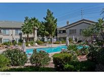 Community pool with chairs and tables, and lush landscaping surrounding the area at 5710 E Tropicana Ave # 2178, Las Vegas, NV 89122