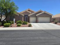 Charming single-story home featuring a well-manicured yard, desert landscaping, and a three-car garage at 6712 Tattler Dr, North Las Vegas, NV 89084