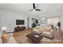 Bright, staged living room with modern furnishings, ceiling fan and seamlessly flowing into a kitchen with island seating at 728 Carpenter Dr, Las Vegas, NV 89107