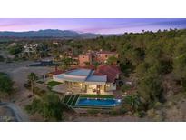 Luxury home with pool, fire pit, and mountain views, set amongst mature trees and greenery, and manicured landscaping at 1 Costa Del Sol Ct, Henderson, NV 89011