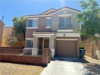Two-story home with a two-car garage and well-maintained front yard showcasing its appealing curb appeal at 10381 Poker Alice Ct, Las Vegas, NV 89129