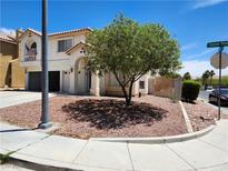 Charming two-story home with attached garage and tidy xeriscaped front yard and a decorative tree at 10968 Geyser Peak St, Henderson, NV 89052