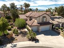 Inviting home features desert landscaping, a two-car garage, and a classic tile roof at 1721 Mill Canyon Dr, Las Vegas, NV 89128
