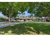 Charming single-story home featuring a well-manicured lawn, mature trees, and a circular driveway at 204 Canyon Dr, Las Vegas, NV 89107